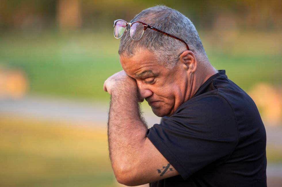 Carlos Gurri wipes away tears while visiting the grave of former FBI Special Agent John Bailey ...