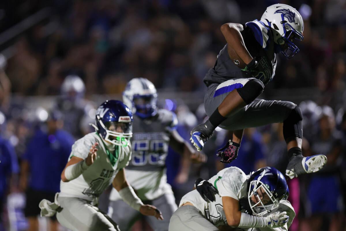 Basic’s Elijah Jones (8) leaves over Green Valley players before scoring a touchdown dur ...