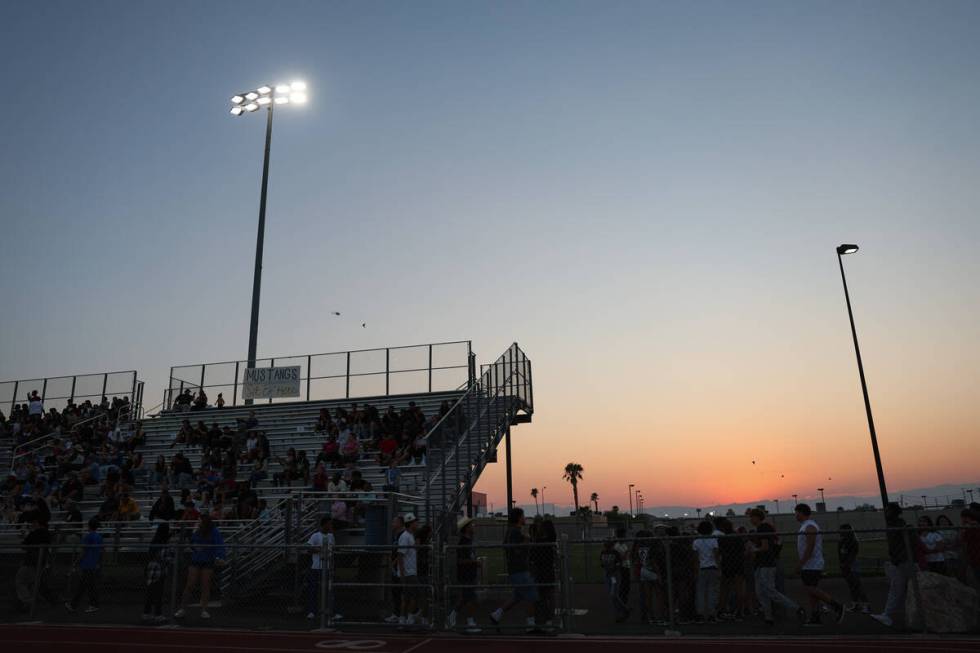 The sun sets behind the stands during a high school football game between Basic and Green Valle ...