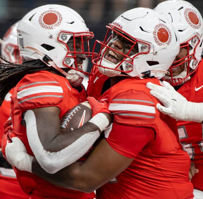 After scoring a touchdown, UNLV running back Devin Green, left, is lifted up by offensive linem ...