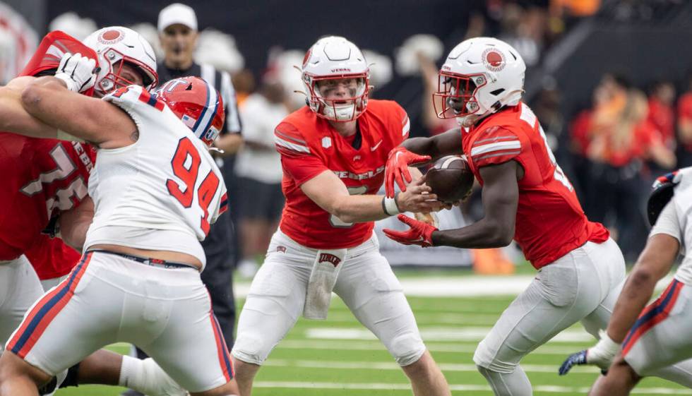 UNLV quarterback Matthew Sluka (3) hands the ball to running back Greg Burrell (5) during the c ...