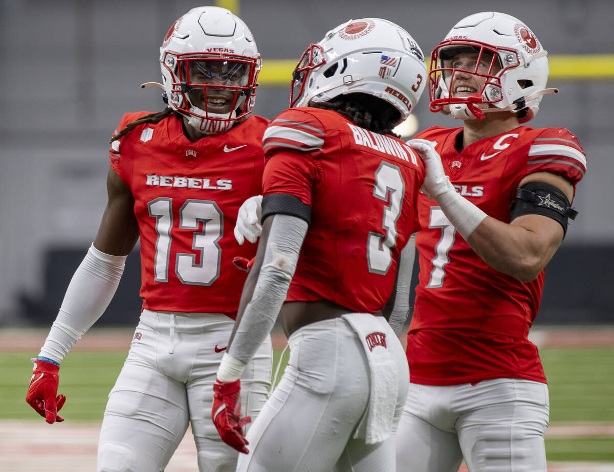 UNLV defensive back Jarvis Ware (13) and linebacker Jackson Woodard (7) comfort defensive back ...