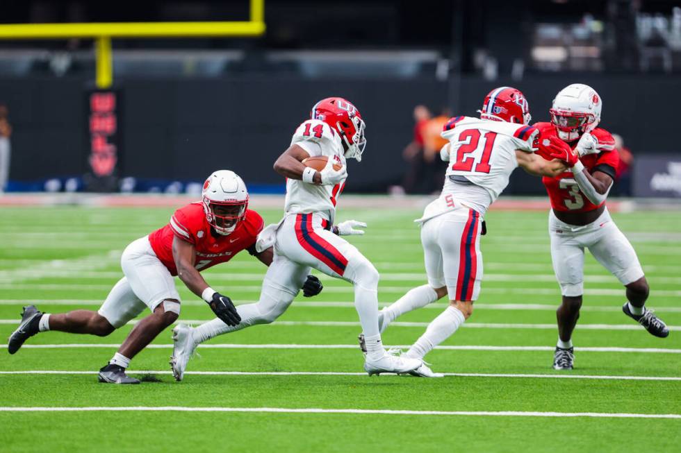 Utah Tech Trailblazers wide receiver Bryce Parker (14) carries the ball as UNLV Rebels defensiv ...