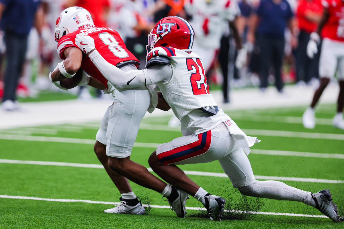 Utah Tech Trailblazers defensive back Foster Slaughter (21) drags UNLV Timothy Conerly (8) down ...