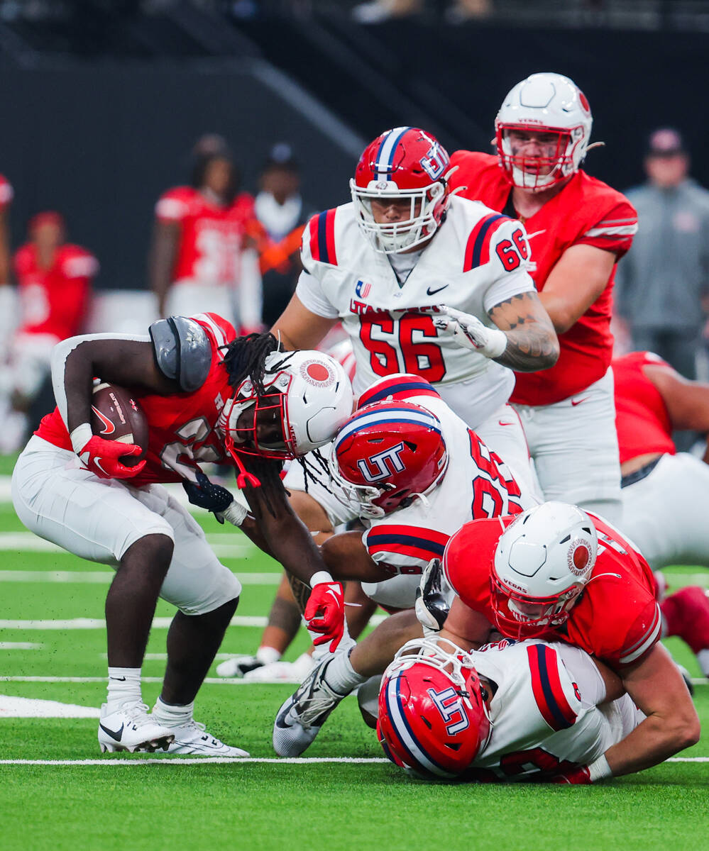 UNLV defensive back Elijah Wilson (22) is dragged down by his jersey by Utah Tech linebacker Ri ...