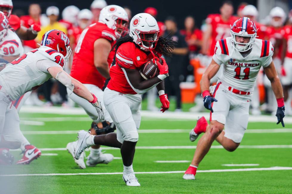 UNLV defensive back Elijah Wilson (22) moves the ball past Utah Tech defenders during an NCAA f ...