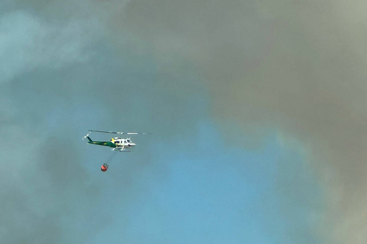 A helicopter drops water of the Davis Fire near South Reno on Sunday, Sept. 8, 2024. (Christy C ...