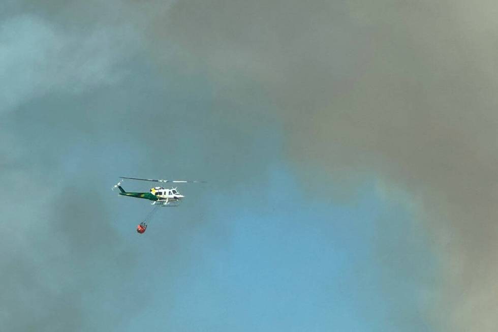 A helicopter drops water of the Davis Fire near South Reno on Sunday, Sept. 8, 2024. (Christy C ...