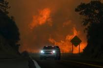 The Line Fire jumps highway 330 as an emergency vehicle is driven past Saturday, Sept. 7, 2024, ...