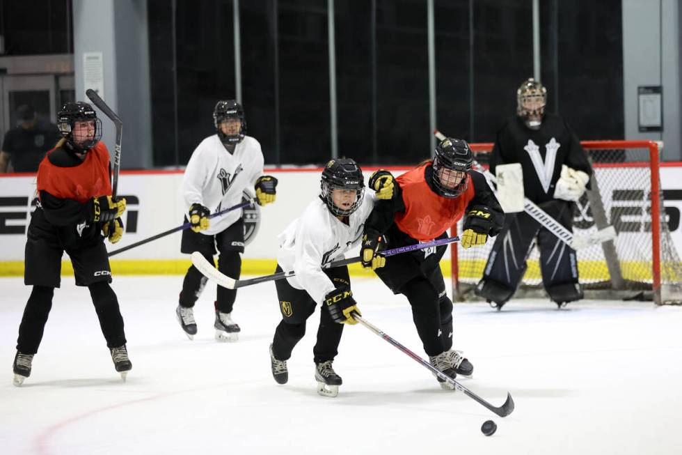 Vegas Jr. Golden Knights 14U Girls team players vie for the puck during practice at America Fir ...