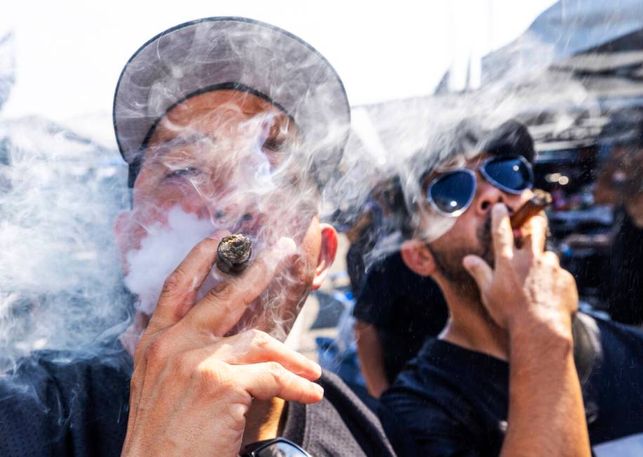 Mike Orozco of Los Angeles and a friend enjoy cigars in the tailgate area before the Raiders fa ...