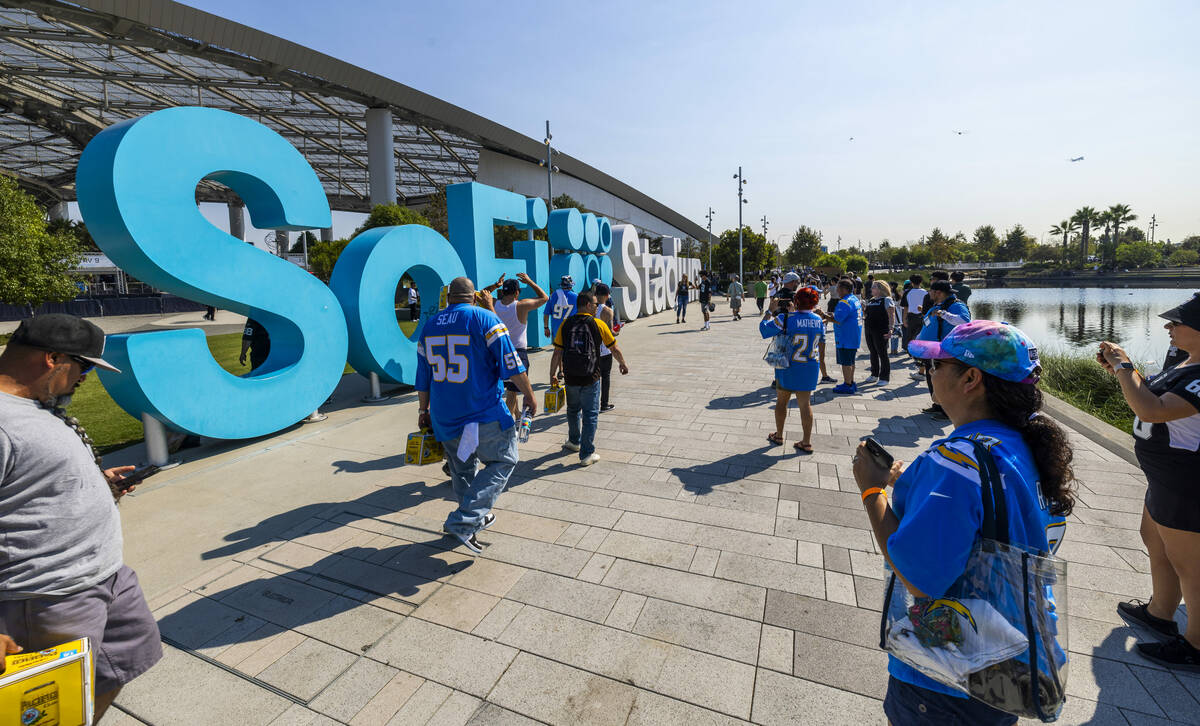 Fans walk about outside the stadium before the Raiders face the Los Angeles Chargers in an NFL ...