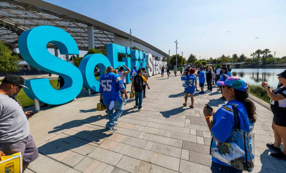 Fans walk about outside the stadium before the Raiders face the Los Angeles Chargers in an NFL ...