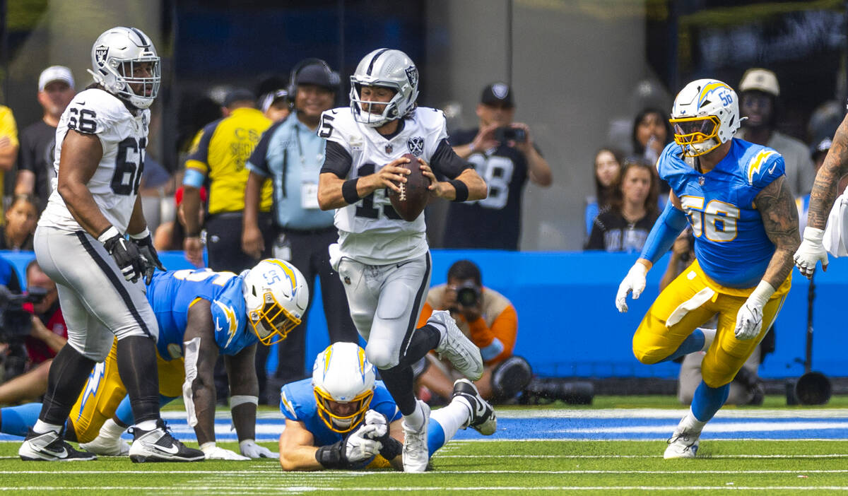 Raiders quarterback Gardner Minshew (15) takes off on a run and avoids a Los Angeles Chargers t ...