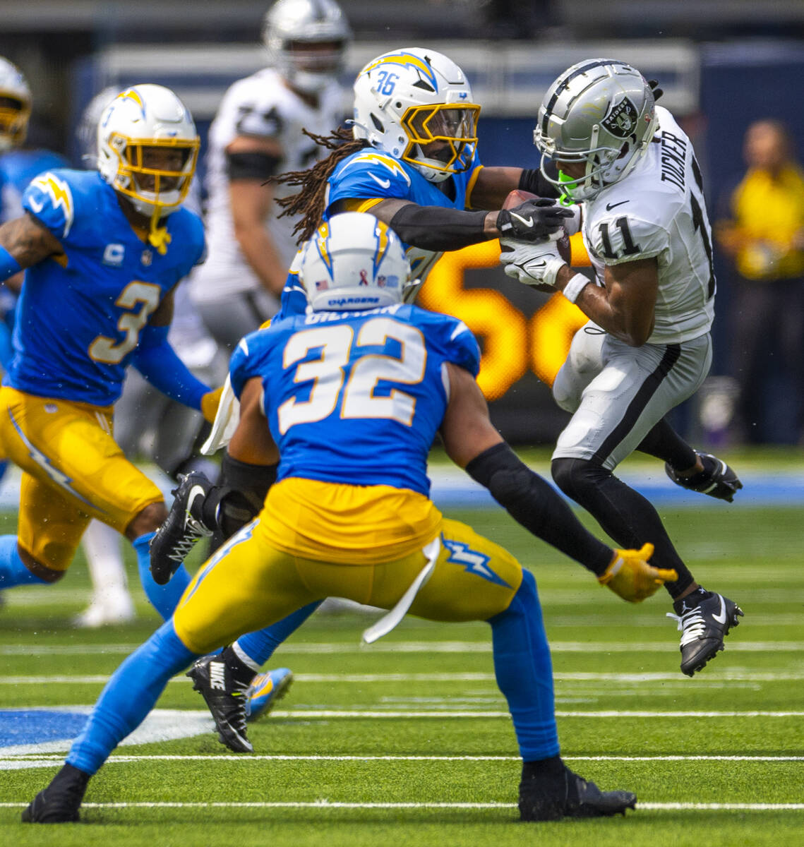 Raiders wide receiver Tre Tucker (11) battles for a pass with Los Angeles Chargers cornerback J ...