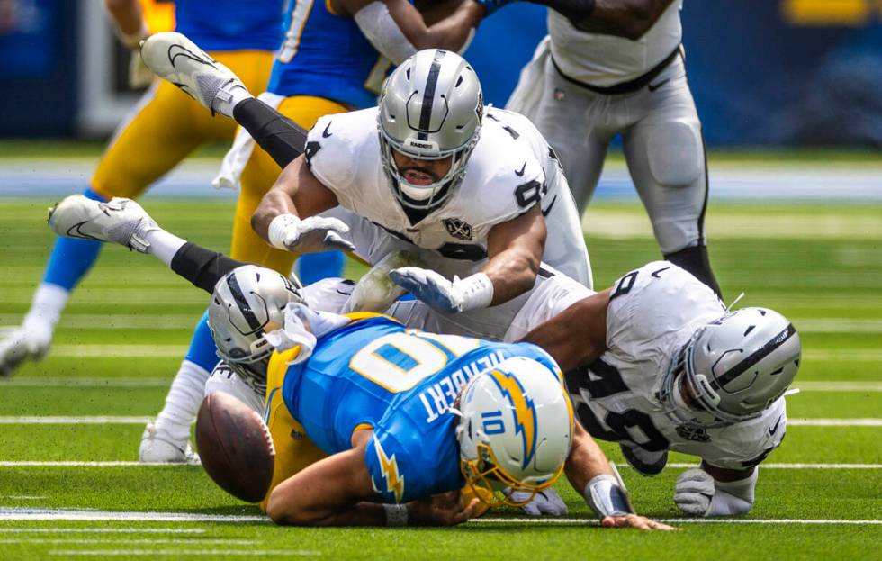 Los Angeles Chargers quarterback Justin Herbert (10) fumbles the ball after a big hit by Raider ...