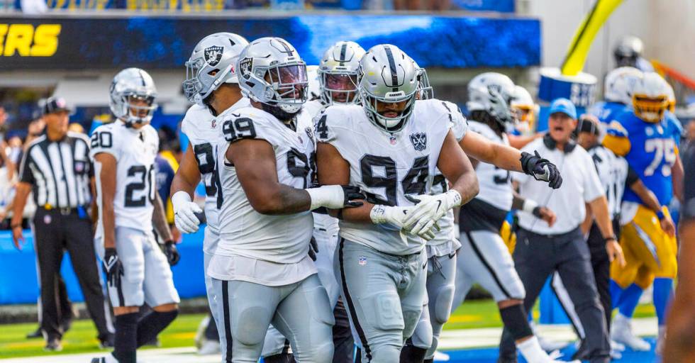 Raiders defensive tackle Christian Wilkins (94) holds his hand while being escorted off by defe ...