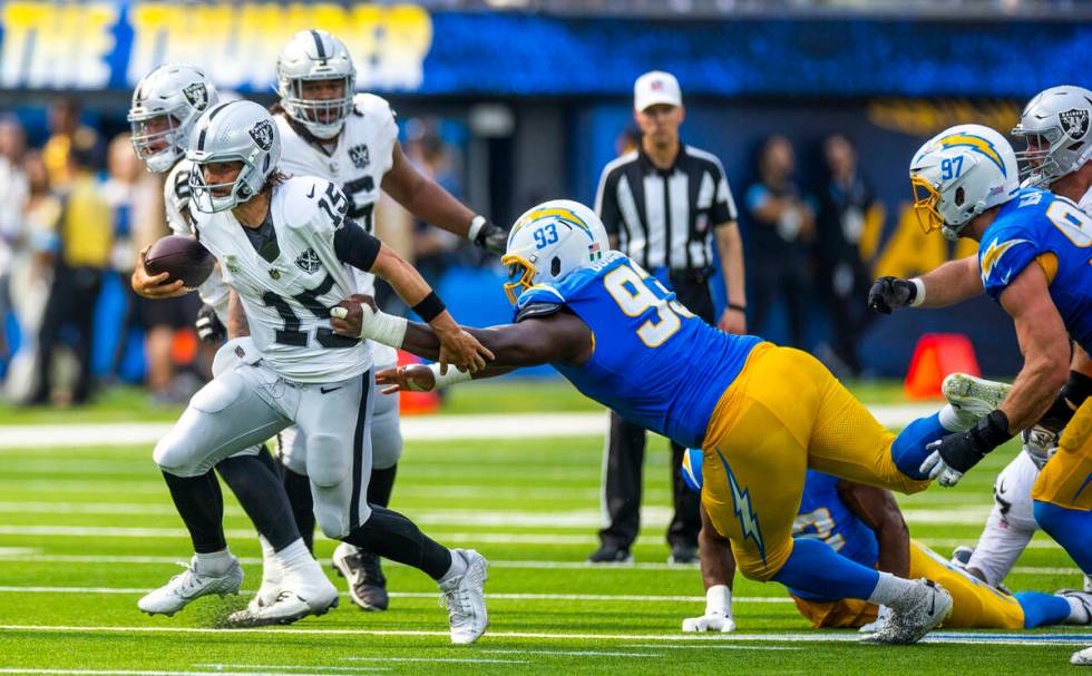 Raiders quarterback Gardner Minshew (15) breaks free for a run with a grab by Los Angeles Charg ...