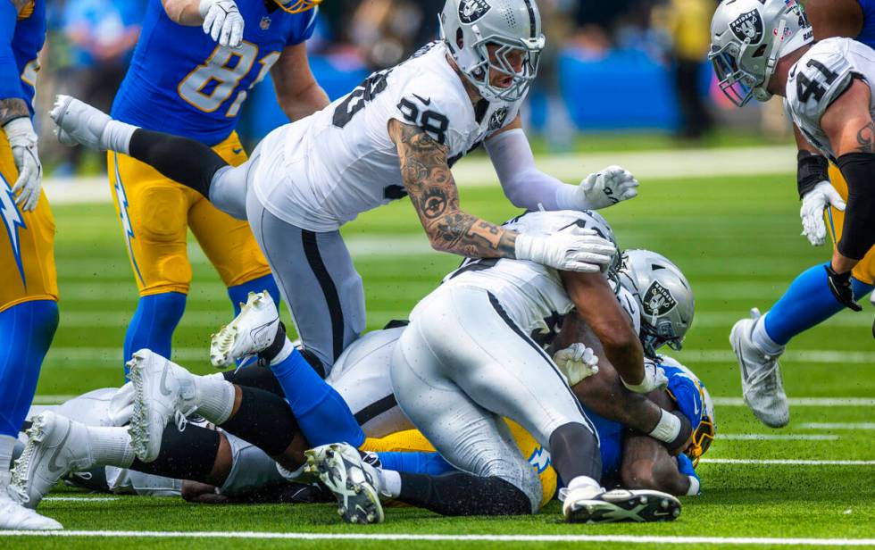 Raiders defensive end Maxx Crosby (98) comes over the top as teammates take down Los Angeles Ch ...