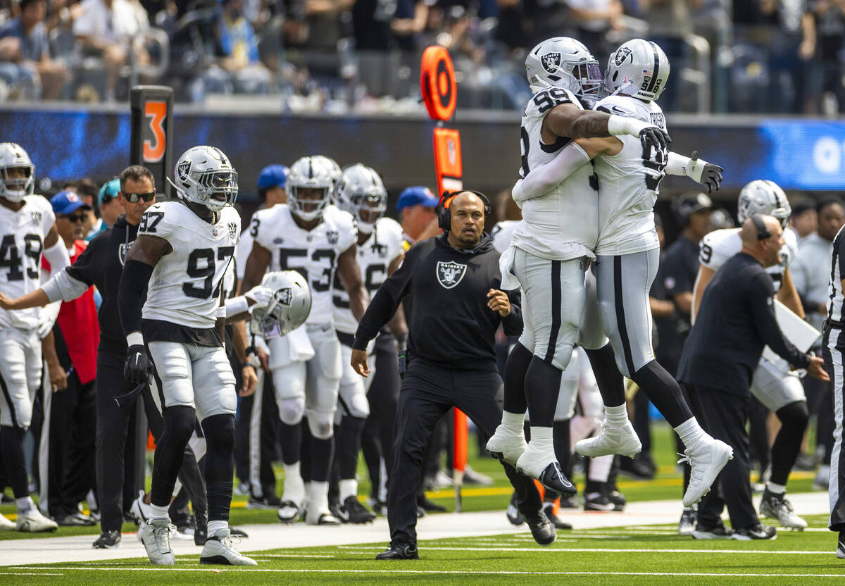 Raiders defensive end Maxx Crosby (98) celebrates a sack with defensive tackle Nesta Jade Silve ...