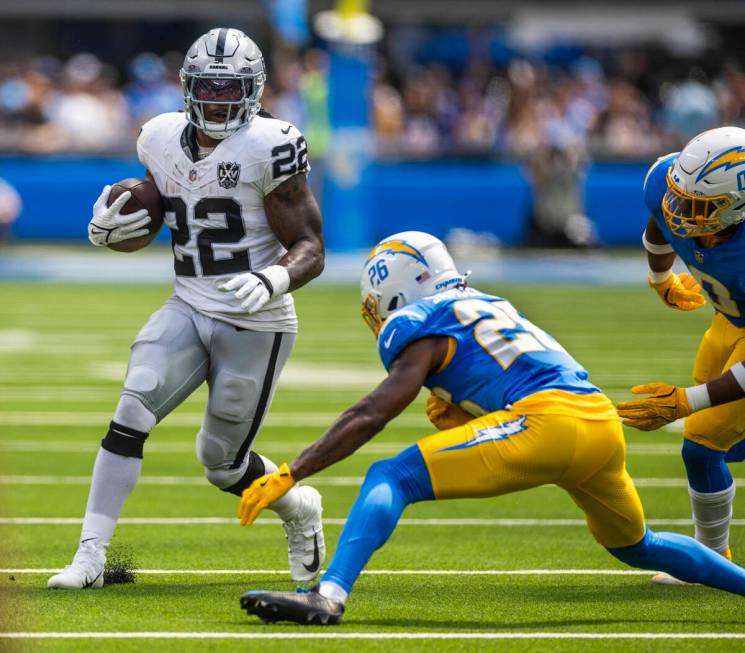 Raiders running back Alexander Mattison (22) sets up to hurdle Los Angeles Chargers cornerback ...