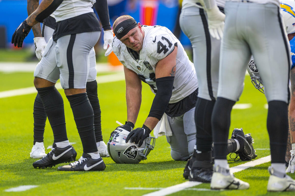 Raiders linebacker Robert Spillane (41) is spent on the field as the game nears and end against ...