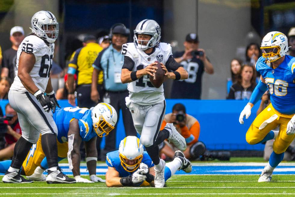 Raiders quarterback Gardner Minshew (15) takes off on a run and avoids a Los Angeles Chargers t ...