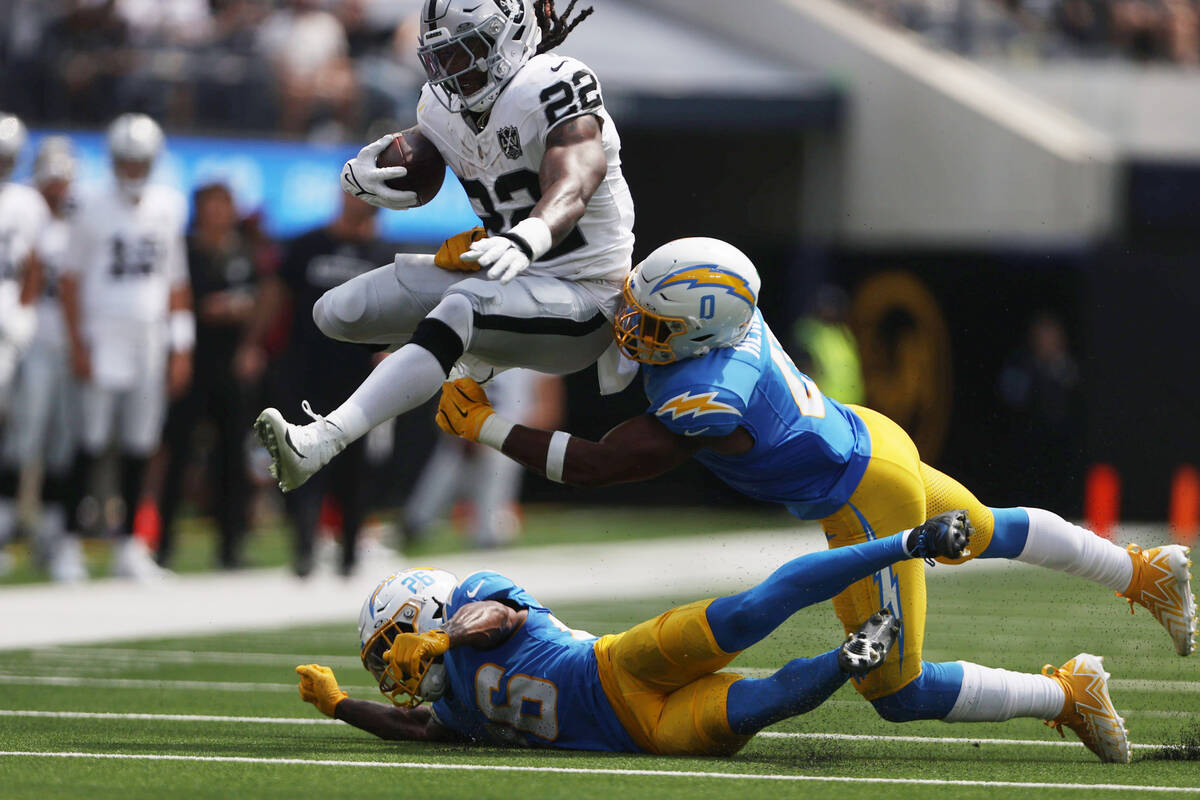 Raiders running back Alexander Mattison (22) hurdles over Los Angeles Chargers cornerback Asant ...