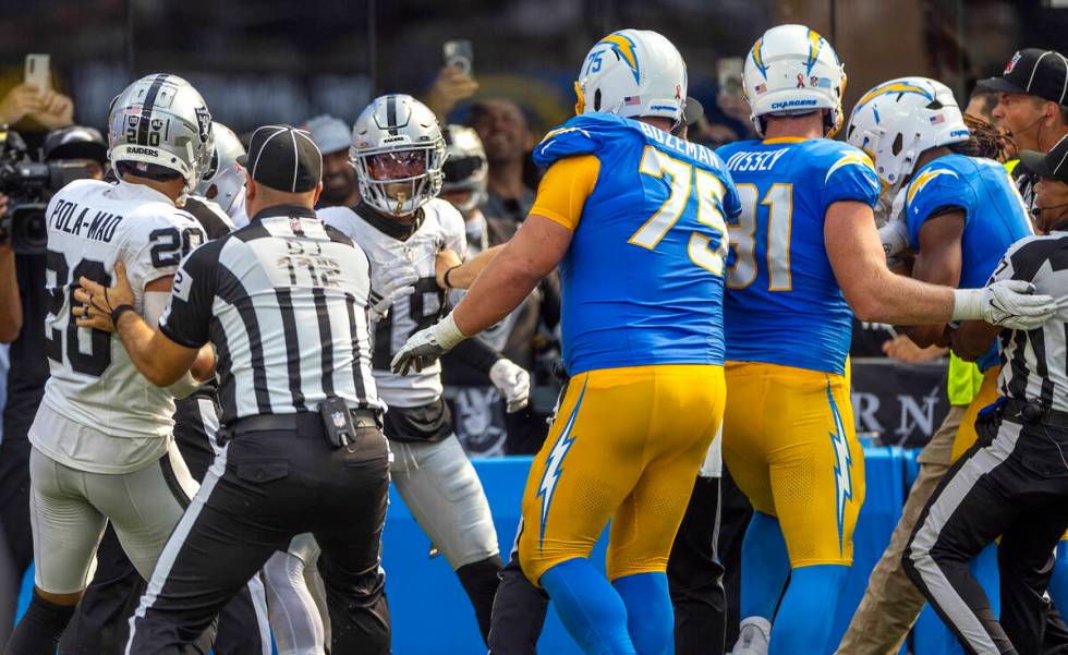 Raiders cornerback Jack Jones (18) is held back by Los Angeles Chargers center Bradley Bozeman ...