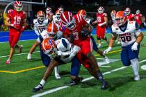 Mater Dei running back Jordon Davison (0) is swarmed by Bishop Gorman defensive back Jett Washi ...