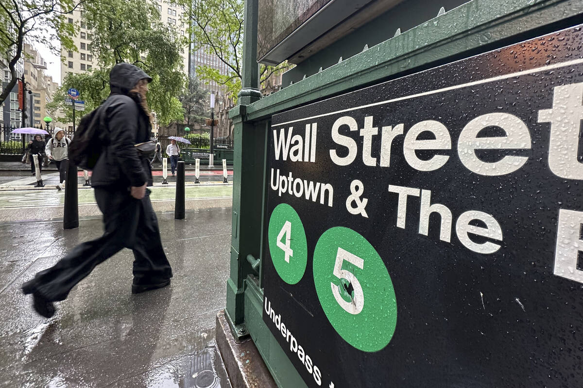 A rider passes an entrance to the Wall Street subway station in New York. (AP Photo/Peter Morgan)