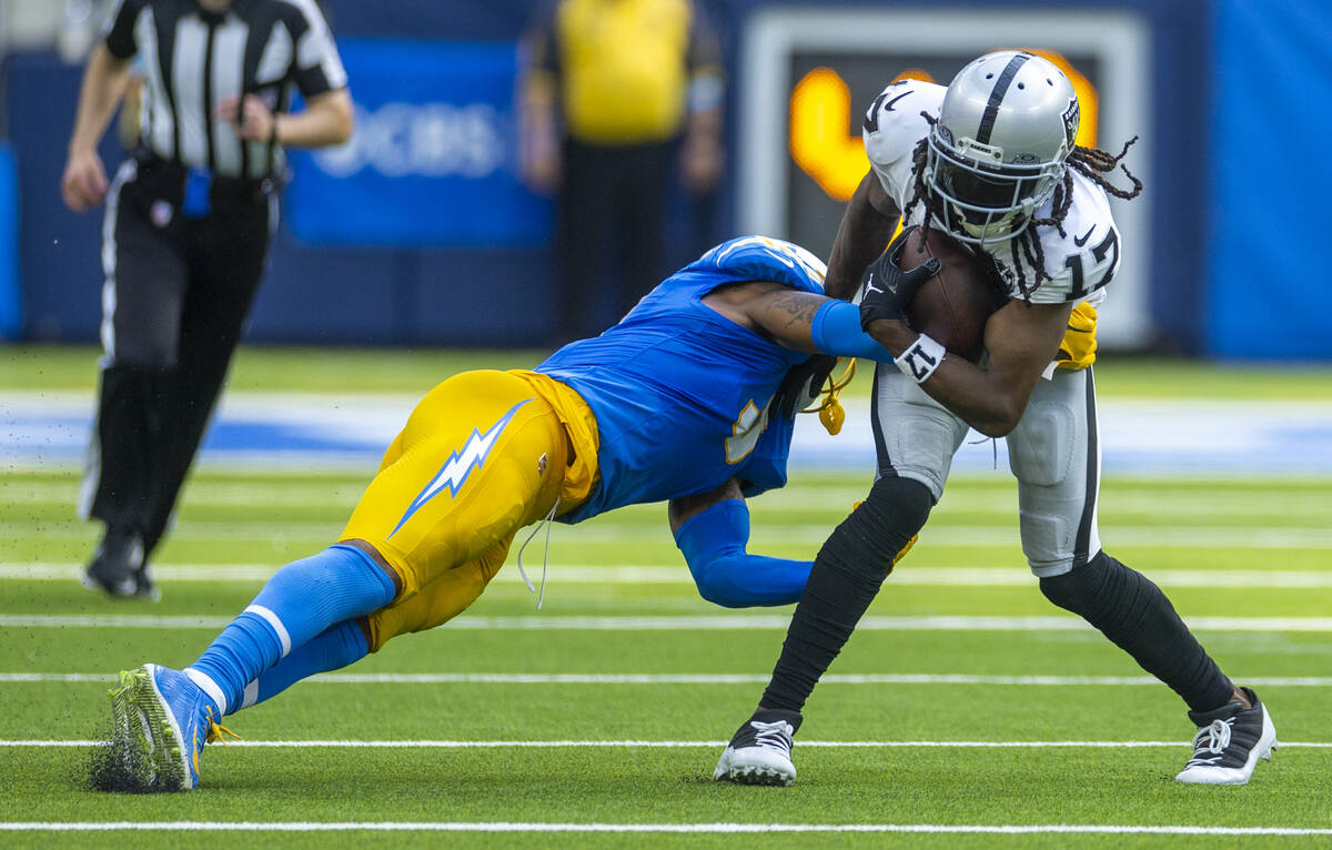 Raiders wide receiver Davante Adams (17) looks to avoid a tackle attempt by Los Angeles Charger ...