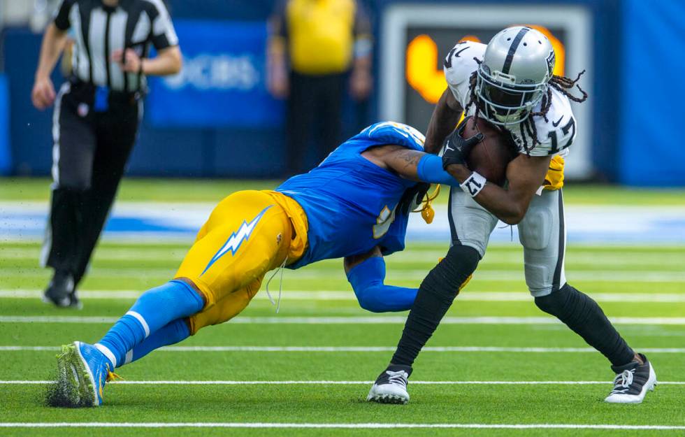 Raiders wide receiver Davante Adams (17) looks to avoid a tackle attempt by Los Angeles Charger ...