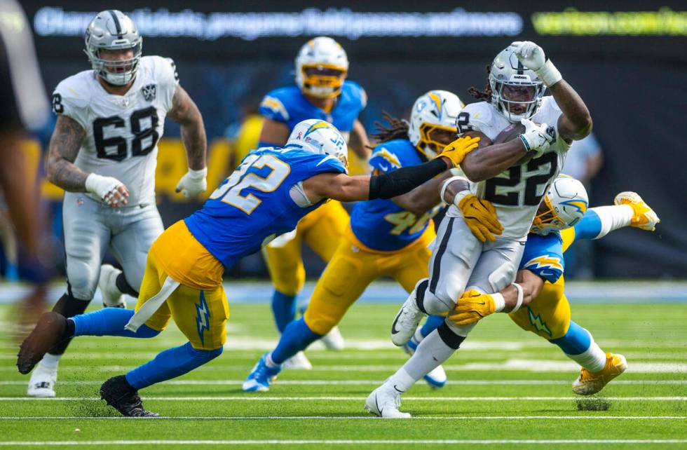 Raiders running back Alexander Mattison (22) is swarmed by Los Angeles Chargers defenders durin ...