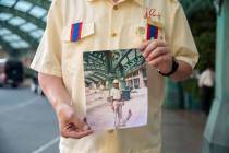 James Ealey, a Paris Las Vegas day-one employee, stands with a photograph from his first day of ...