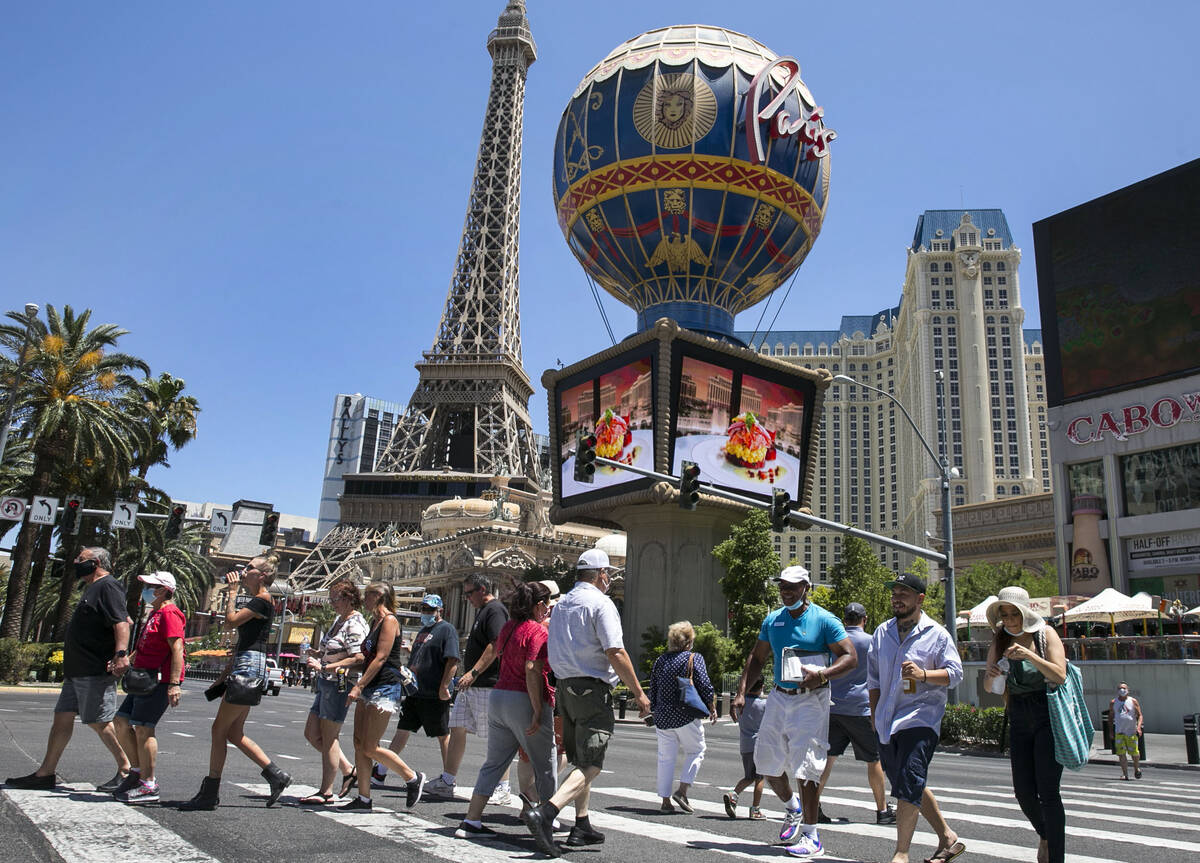 Tourists cross Las Vegas Boulevard near Paris hotel-casino on Friday, July 3, 2020, in Las Veg ...