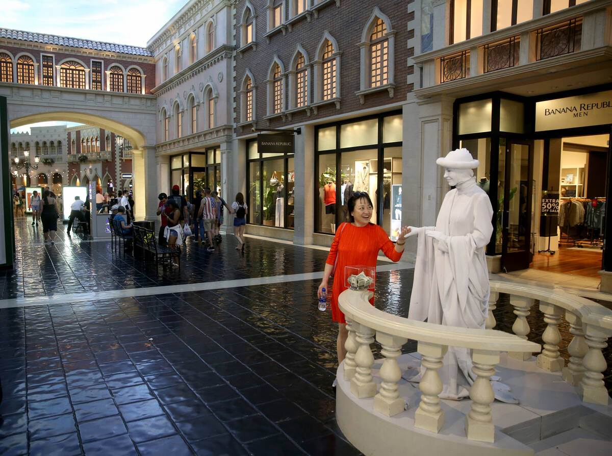 Judy Guo of Canada greets a living statue at The Venetian on the Strip in Las Vegas Thursday, A ...