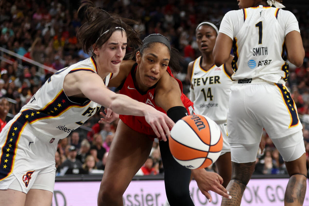 Indiana Fever guard Caitlin Clark, left, and Las Vegas Aces center A'ja Wilson, center, vie for ...