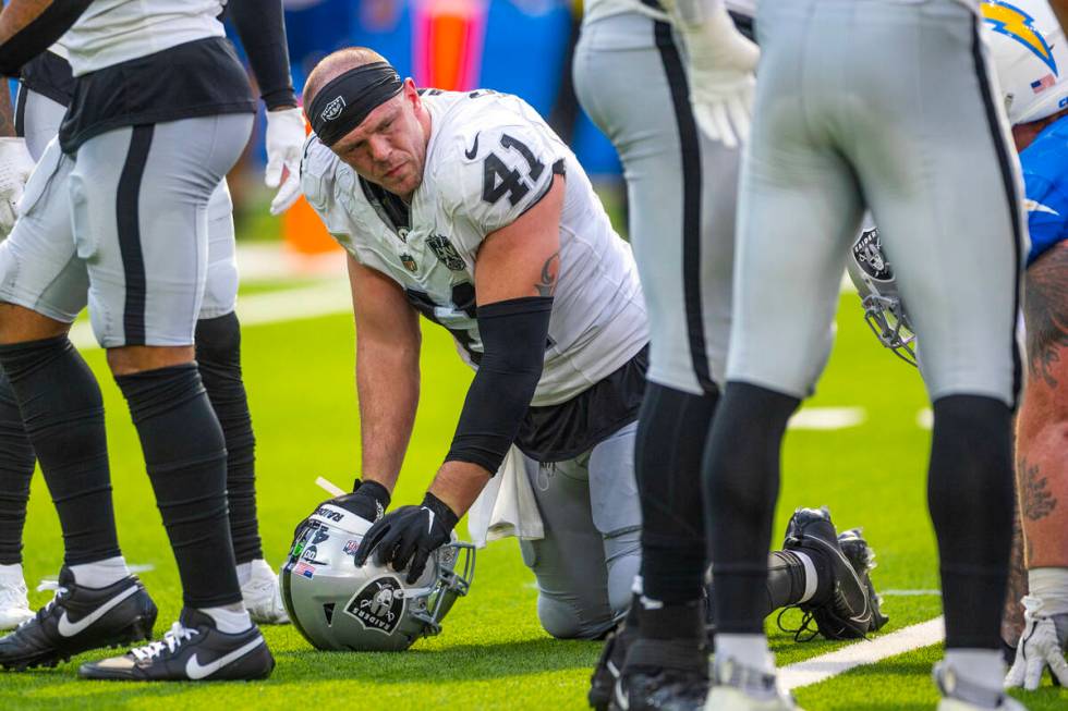 Raiders linebacker Robert Spillane (41) is spent on the field as the game nears and end against ...