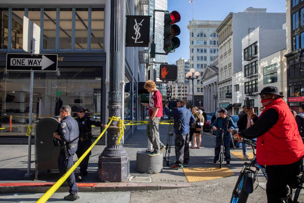 Police officers secure the area and investigate the scene of a shooting at Union Square in San ...