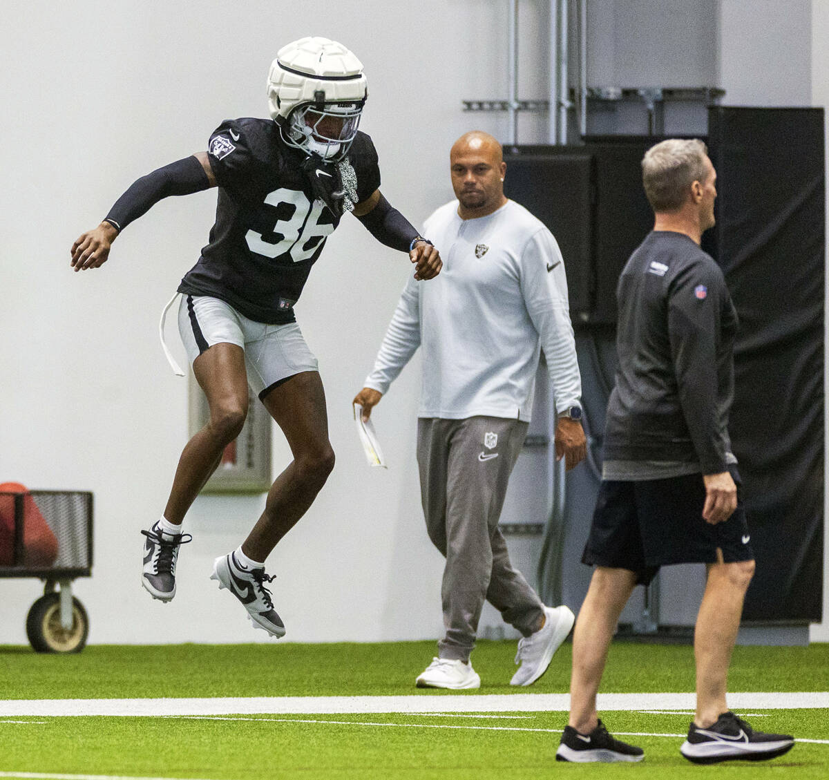 Raiders cornerback Kyu Blu Kelly (36) jumps in warm ups as head coach Antonio Pierce walks pas ...