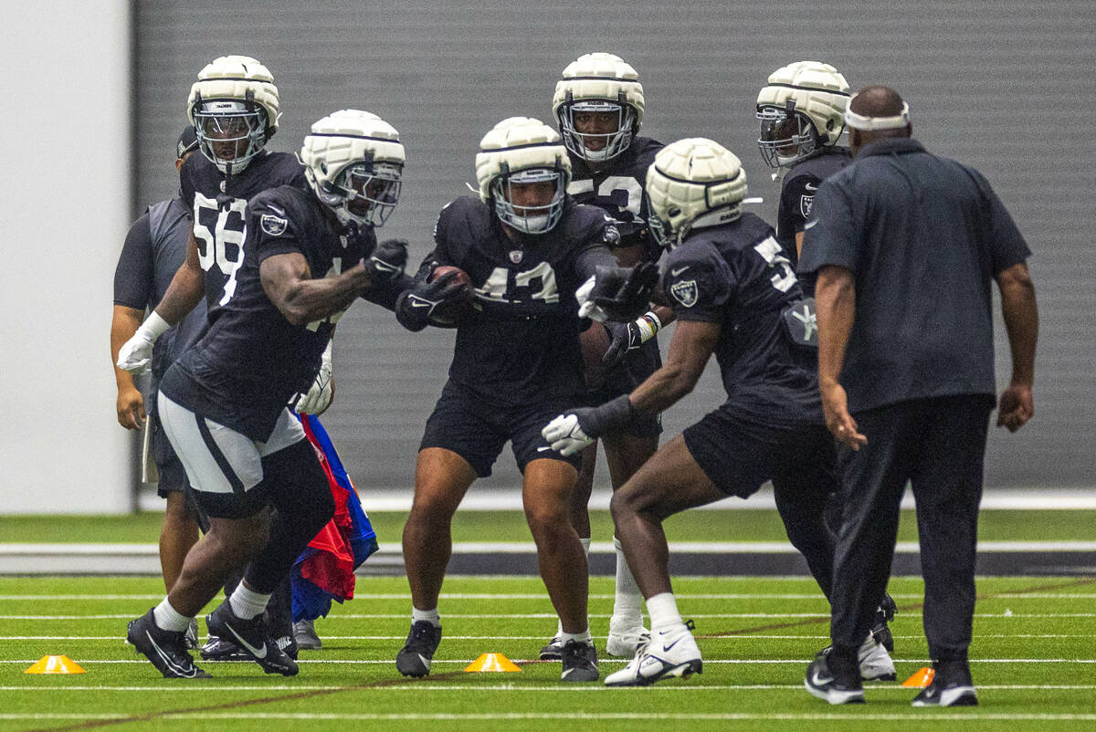 Raiders linebacker K'Lavon Chaisson (44) attempts to knock the ball loose from linebacker Kana' ...