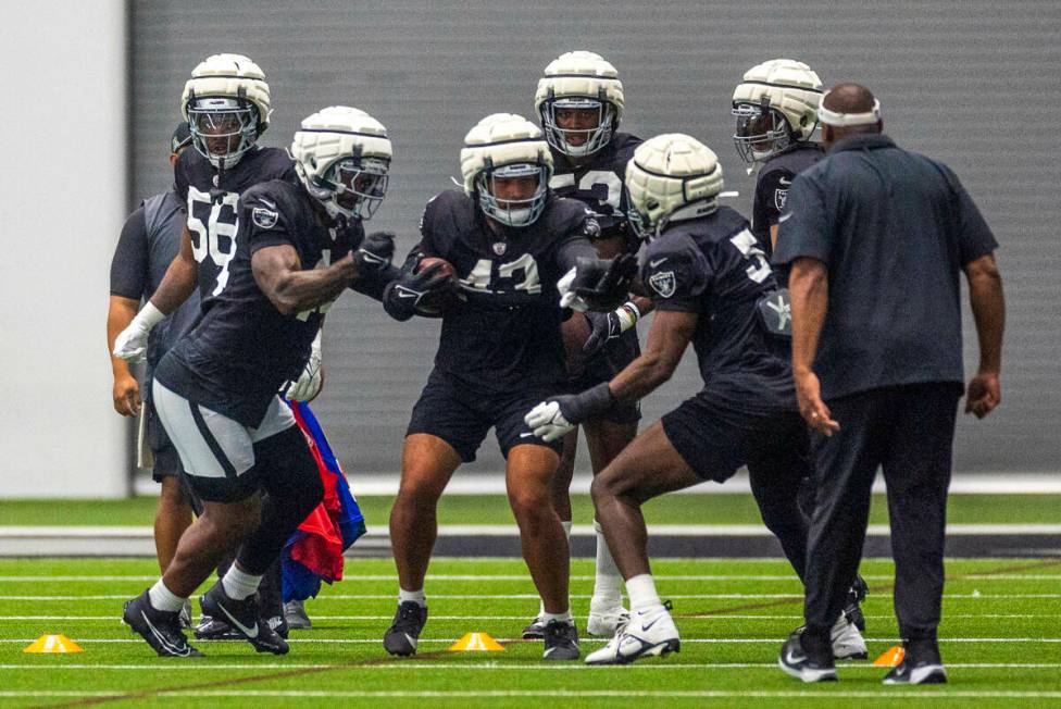 Raiders linebacker K'Lavon Chaisson (44) attempts to knock the ball loose from linebacker Kana' ...