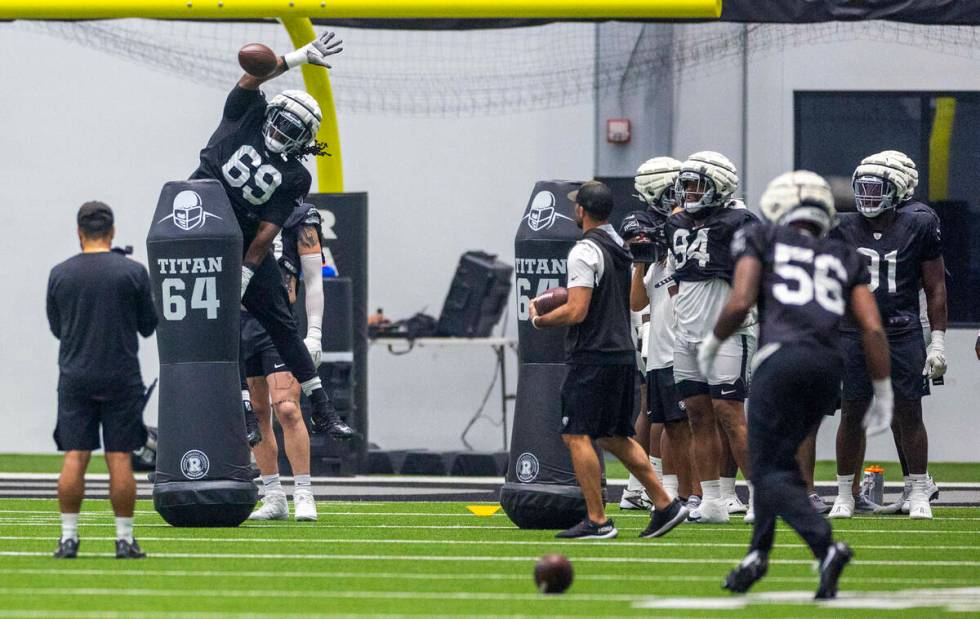 Raiders defensive tackle Adam Butler (69) attempts to swat down a ball during practice at the I ...