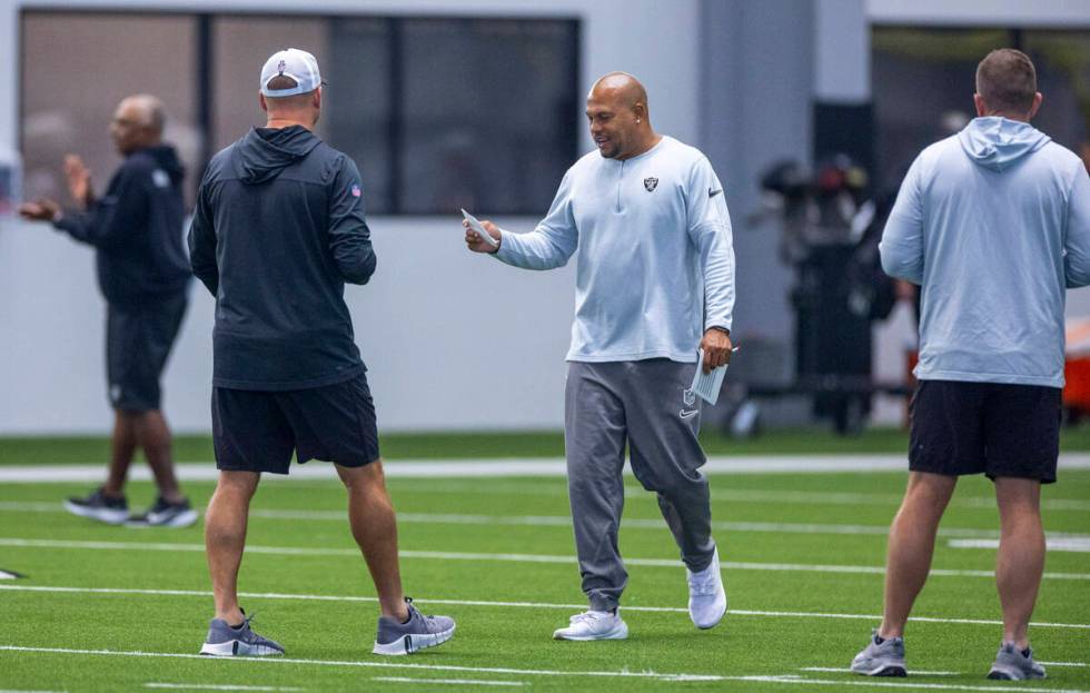 Raiders head coach Antonio Pierce talks with other coaches during practice at the Intermountain ...