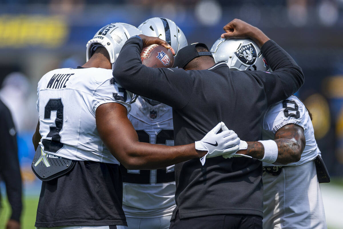 Raiders running backs coach Carnell Williams gathers with running back Zamir White (3), running ...