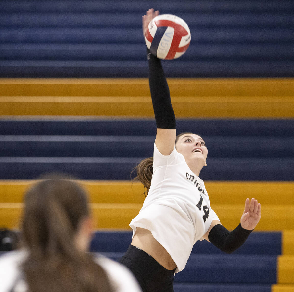 Faith Lutheran senior Sienna Lopez (14) spikes the ball during the high school volleyball game ...