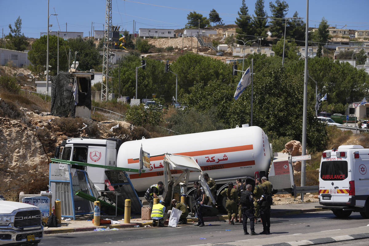 Israeli security forces inspect the scene of what they say is a Palestinian ramming attack at a ...