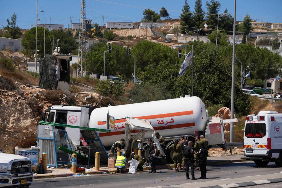 Israeli security forces inspect the scene of what they say is a Palestinian ramming attack at a ...