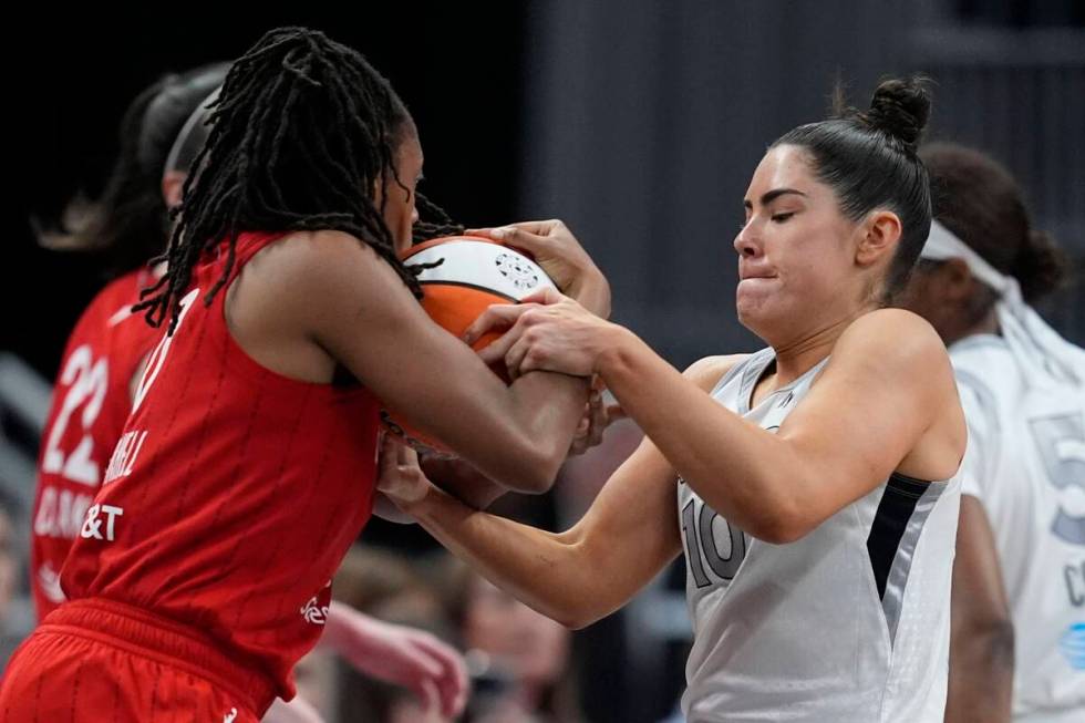 Indiana Fever's Kelsey Mitchell and Las Vegas Aces' Kelsey Plum battle for a loose ball during ...